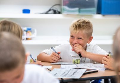 Student smiling and writing
