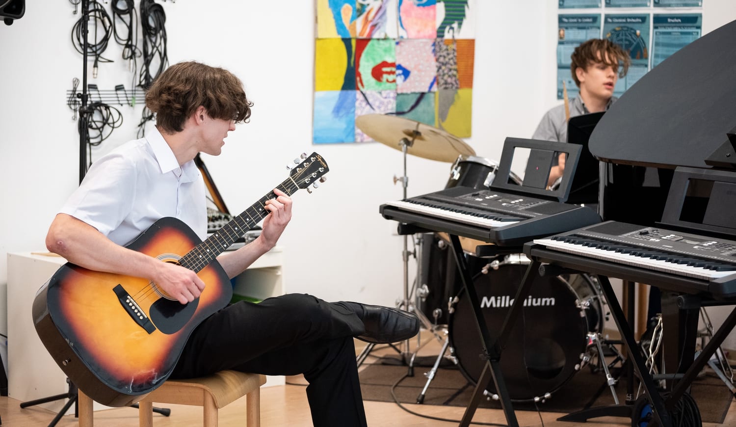 Students playing piano and guitar in school
