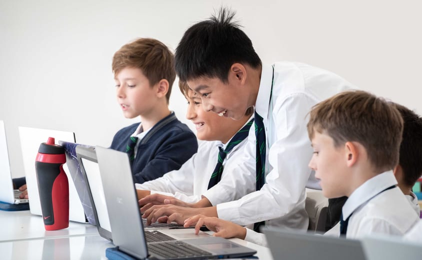 Students working with computers and smiling